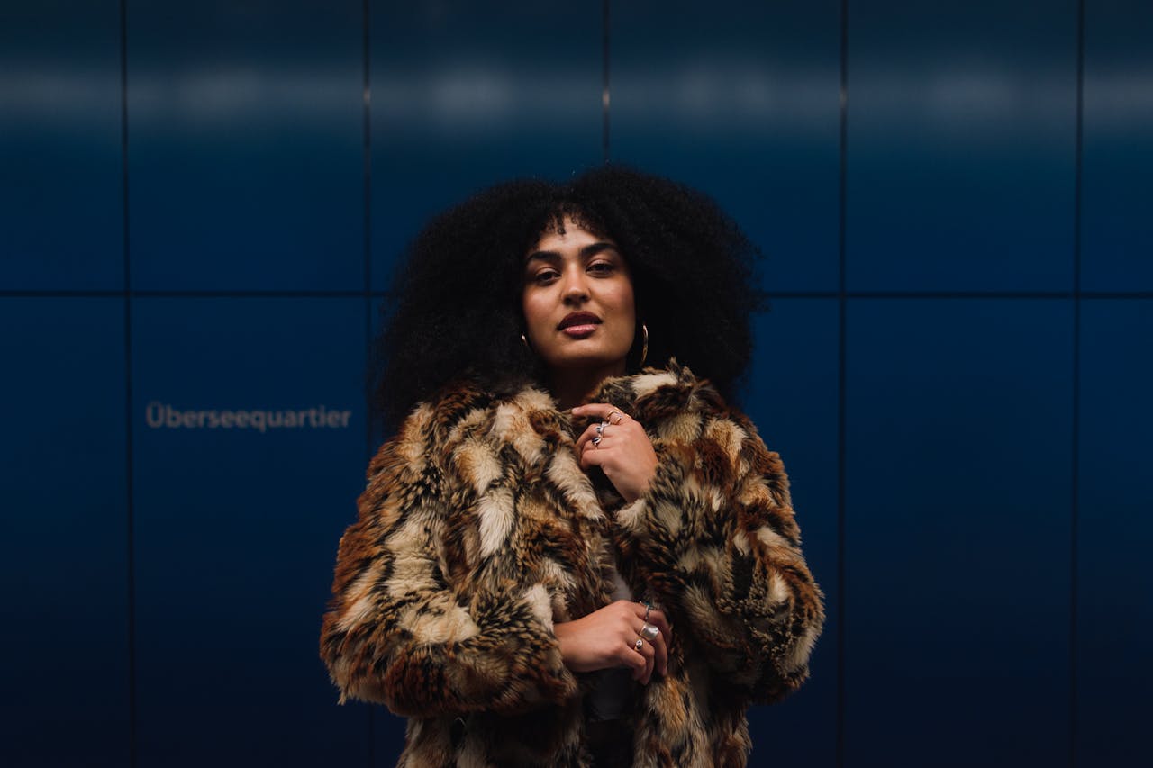 Portrait of a fashionable woman wearing a faux fur coat at Überseequartier station in Hamburg.